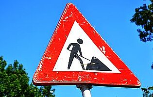 Foto van een verkeersbord dat aangeeft dat er wegwerkzaamheden zijn.